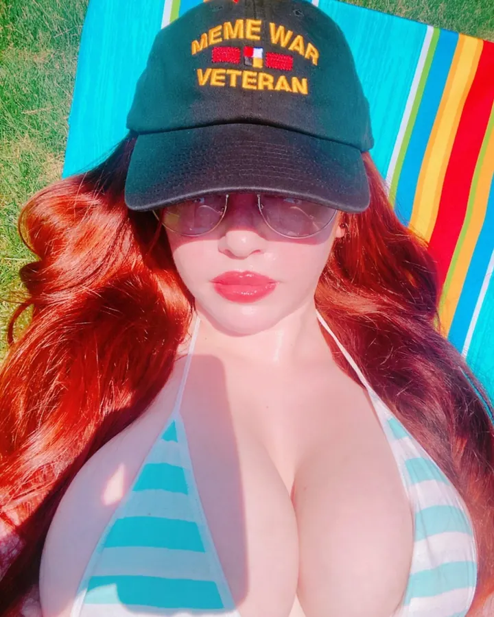 Jeune femme rousse en maillot de bain et casquette