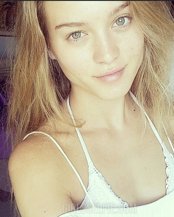 Jeune femme blonde en haut blanc et jupe noire