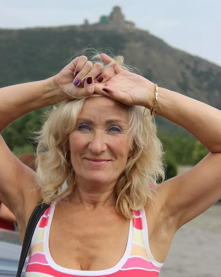 Femme blonde aux yeux bleus mains sur la tête