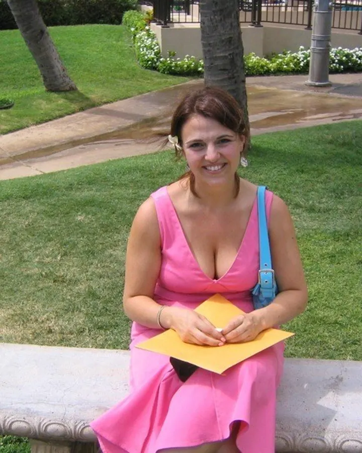 Femme en haut rose, assise sur un banc, tenant un papier jaune