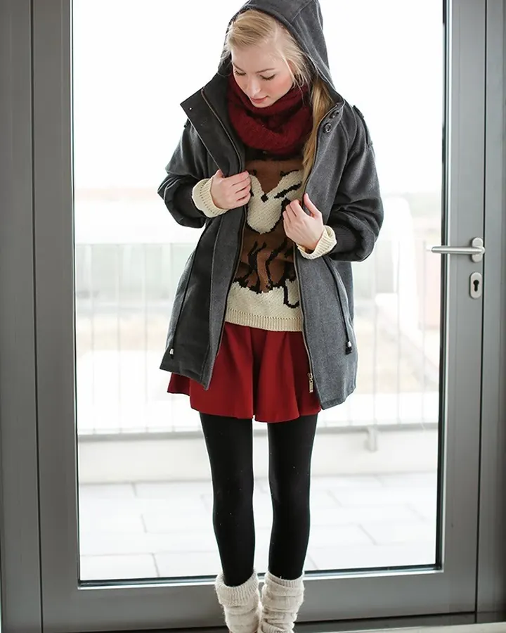 Femme en veste grise et foulard rose, souriant à l'appareil