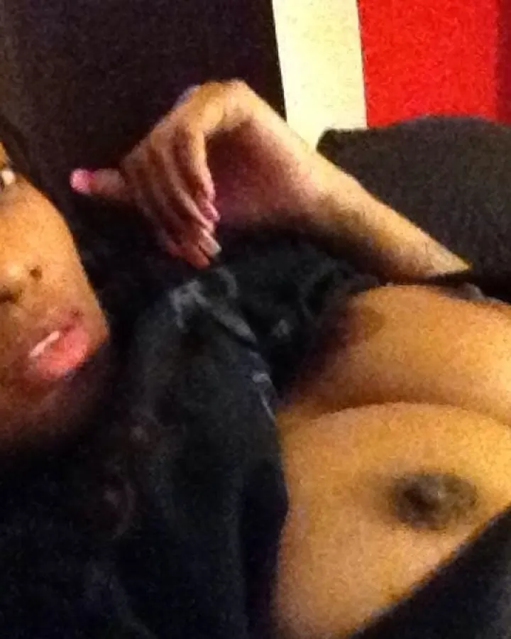 Femme africaine en sous-vêtements noirs, allongée sur un lit, regardant vers le haut